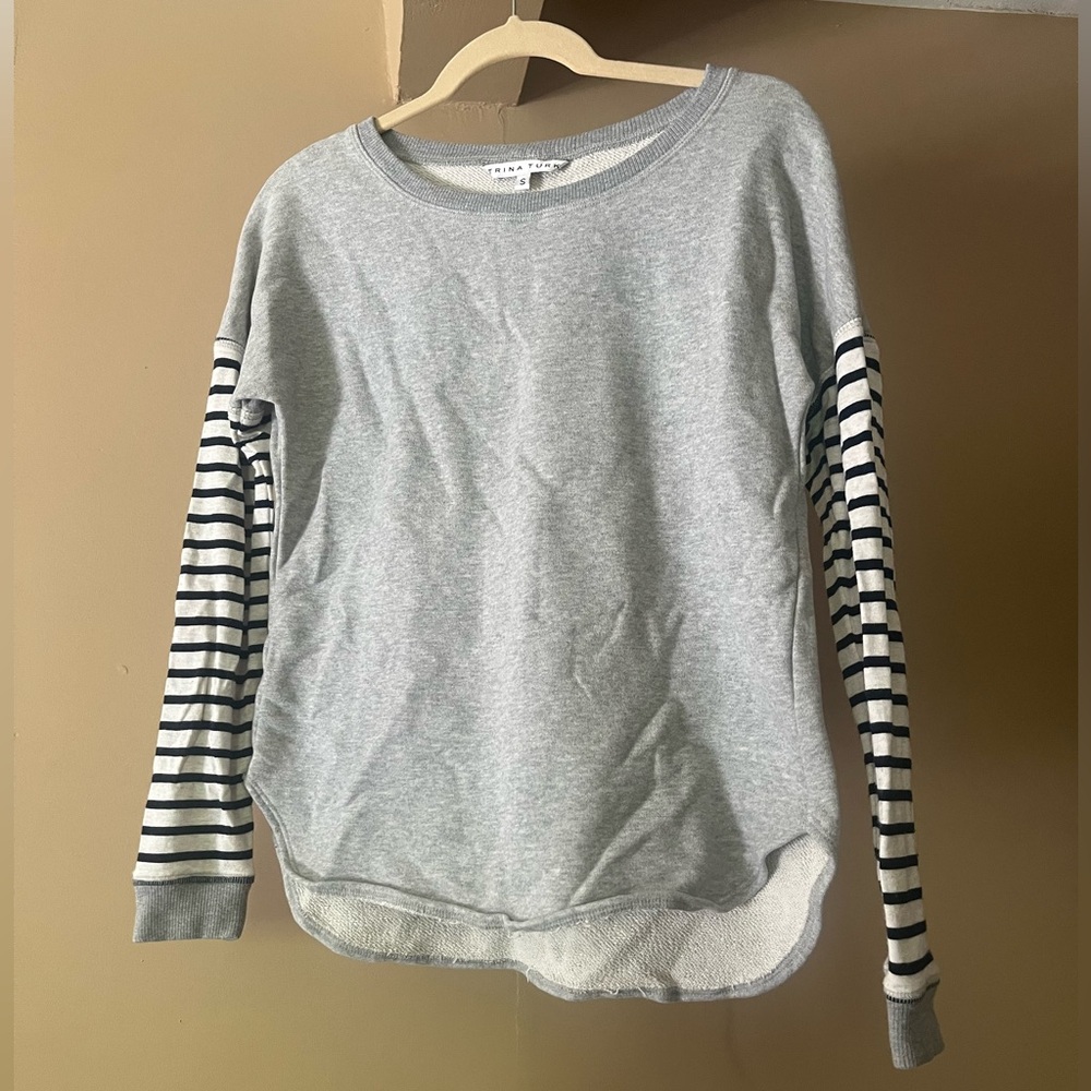Gray Trina Turk sweater with striped sleeves.
